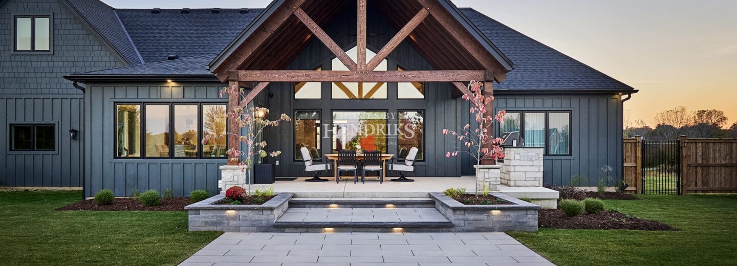 A spacious rear patio featuring a mix of natural stone and rustic timber accents, providing a perfect space for outdoor dining and relaxation.