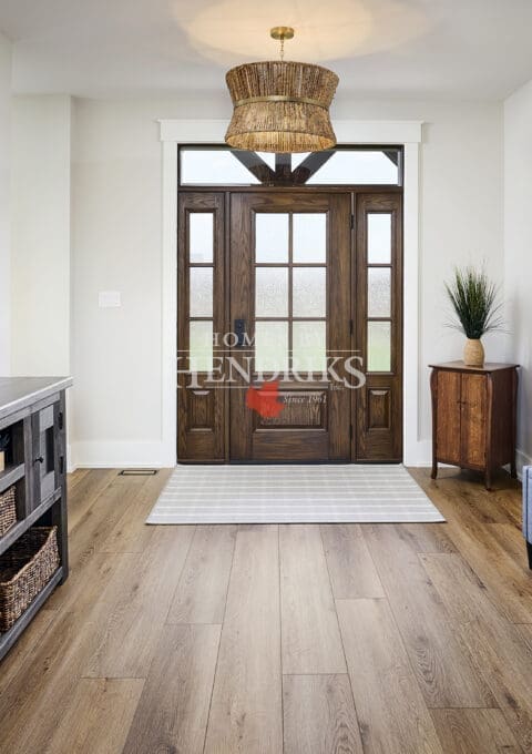 A welcoming front entryway featuring a custom wooden door with intricate detailing and rich, natural wood finishes.