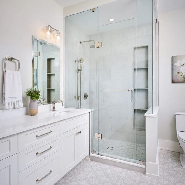 The primary ensuite design is enhanced by natural stone countertops and elegant lighting, creating a serene and sophisticated space.