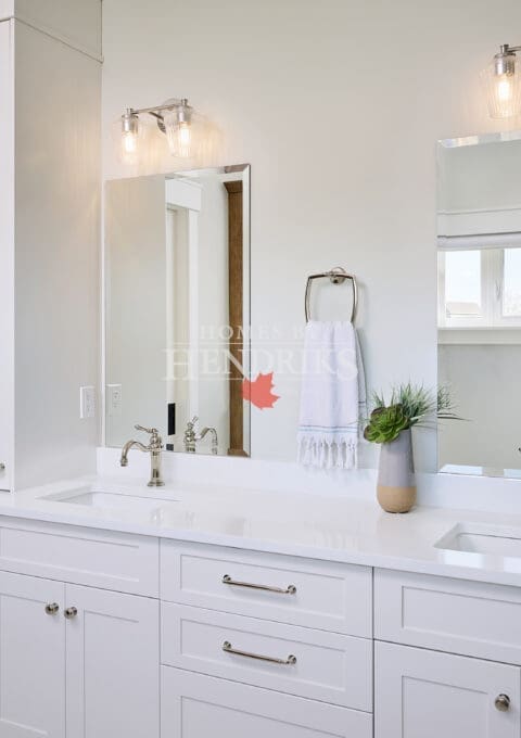 A stylish primary ensuite featuring crisp white cabinetry that offers a clean, modern look. The cabinets provide ample storage while maintaining a bright and airy atmosphere, complemented by sleek hardware and a neutral color palette.