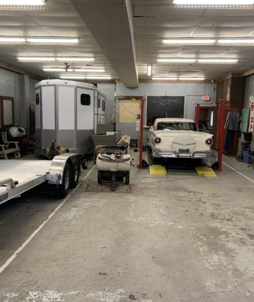 Interior of the old firehouse showing exposed brick walls, concrete floors, and remnants of equipment bays